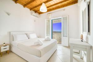 普拉迪斯亚罗斯Lofos Apartments的一间白色卧室,配有床和阳台