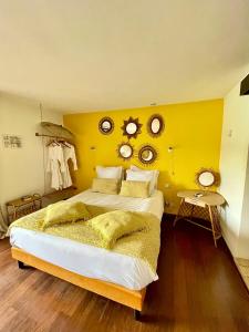 滨海萨纳里欧佩蒂特蒙德酒店的一间卧室设有一张黄色墙壁的大床