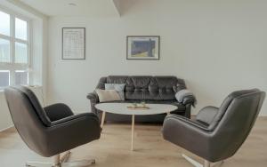 HvalvíkDahlastova / Stunning Boathouse / Bay View / 3BR的客厅配有沙发、两把椅子和一张桌子