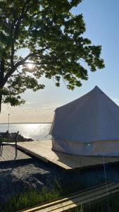 DrottningskärAspö Glamping的湖畔码头上的帐篷