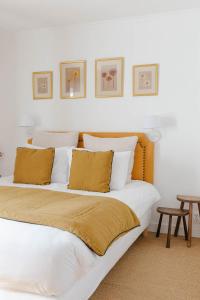 MaisonsFerme des Goupillières的一间卧室配有两张带白色床单和黄色枕头的床。