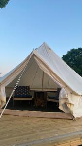 DrottningskärAspö Glamping的帆布帐篷,配有两把椅子和一张桌子