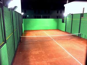卢克Casa Rural Vistaverde的一座空洞的网球场,晚上有绿色的墙壁