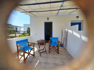 基莫洛斯岛Elzahed apartments orza的享有带椅子和桌子的庭院的景色。