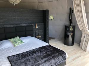 米德尔克尔克ID Glamping De Coude Scheure的一间卧室配有一张大床和黑色床头板
