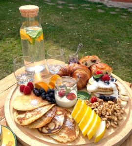 BabiceHand On Heart , ubytování s jógou的桌上放着一盘煎饼、水果和面包