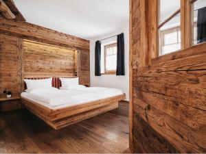 Sankt Lorenzen im LesachtalAlmwellness-Resort Tuffbad的木墙客房的一张床位