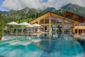 Sankt Lorenzen im LesachtalAlmwellness-Resort Tuffbad的酒店设有一个山地游泳池,