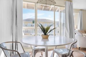 德斯坦Sandpiper Cove 2023的窗户客房内的白色桌椅