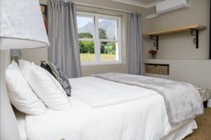斯泰伦博斯Sunset Farm Stellenbosch的卧室配有白色的床和窗户。