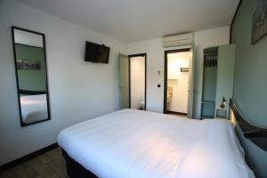 沙特尔Enzo Hotels Chartres Mainvilliers by Kyriad Direct的卧室配有一张白色大床和两面镜子