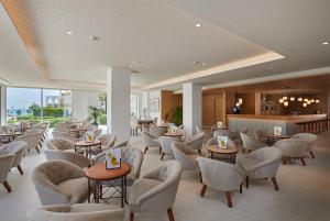卡拉米洛巴伊亚格兰德时尚公寓式酒店的一间设有桌椅的等候室和一间酒吧