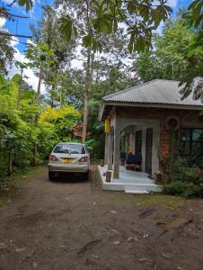 阿鲁沙Arusha Holiday Safari的停在小房子前面的汽车