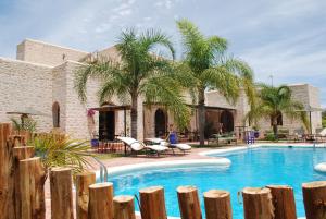 索维拉Riad Titima Essaouira的一座棕榈树游泳池和一座建筑