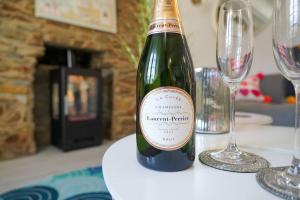 圣莫斯Luxury holiday cottage by the harbour in St Mawes的桌子上摆放着一瓶葡萄酒和眼镜