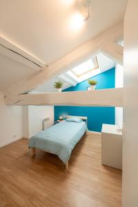 Rive-de-GierKASA DUPLEX - Climatisation - Balcon - Parking Privé的一间卧室设有一张床和蓝色的墙壁