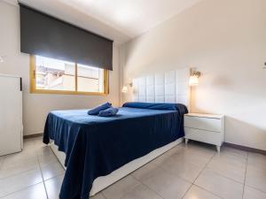 萨洛Apartment Miramar Nautic by Interhome的一间卧室配有一张带蓝色床单的床和一扇窗户。