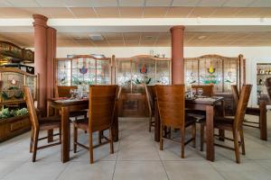贝凯什乔包全景酒店的用餐室配有木桌和椅子