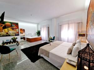 马拉加Hotel Plaza Del Castillo的一间带白色床的卧室和一间客厅
