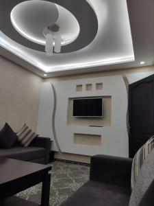 达赫拉Résidence Dahab的客厅设有天花板、电视和沙发。