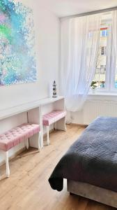 赫尔Apartament Helski的一间卧室设有两个粉红色的长椅和窗户