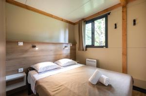 萨尔拉拉卡内达Huttopia Sarlat的一间卧室配有一张大床和两个枕头