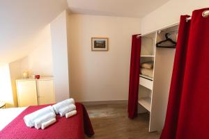 阿姆博斯Le Pont Royal的一间卧室配有一张床和一个衣柜及红色窗帘