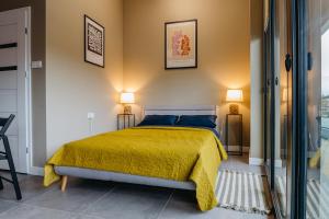 雅罗斯瓦夫APARTAMENTY PRUCHNICKA的一间卧室配有一张带黄色床罩和两盏灯的床。