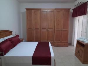 马尔萨什洛克Silver Shadow Holiday Maisonette的一间卧室配有一张大床和木制橱柜。