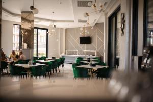 北马马亚-讷沃达里Hotel Grand Dedal的用餐室配有桌子和绿色椅子