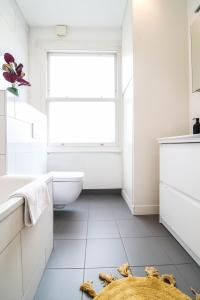 伦敦Modern & spacious 1 bedroom Clapham Junction flat的浴室设有窗户、卫生间和水槽。
