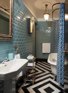 塞维利亚Triana House的浴室设有白色水槽和蓝色瓷砖