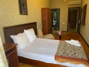 巴库Surf Hotel的一间卧室配有一张带白色床单和一张桌子的床。