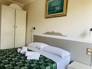 卡尔博尼亚维拉焦餐厅塔尼特酒店的一间卧室配有一张床,上面有两条毛巾