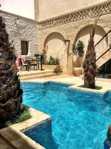 托泽尔Riad Dar El Caid - Palais XIII Siecle的一座带庭院的别墅内的大型游泳池