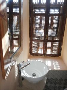 托泽尔Riad Dar El Caid - Palais XIII Siecle的带窗户的浴室内的白色水槽