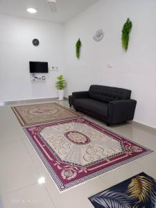 巴西富地Dina Homestay B的客厅配有黑色沙发和地毯。