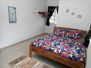 巴西富地Dina Homestay B的一间卧室配有一张带五颜六色棉被的床