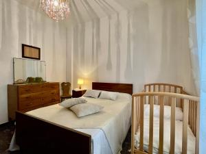 Arnasco[Menosio] La casa di Ermelinda - Relax的一间卧室配有一张床、梳妆台和婴儿床。