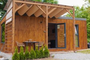 克利默内什蒂Tiny Heaven Cabin的木制棚子,带遮阳篷和桌子