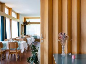 克莱恩 蒙塔纳Chez Elsy - Crans-Sapins的一间带桌椅和花瓶的餐厅