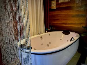 阿布拉奥坎布卡斯溪流酒店的浴室设有白色浴缸,配有窗帘