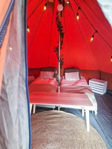 罗瓦涅米Glamping Laenlammen tila的红色帐篷内有两张床