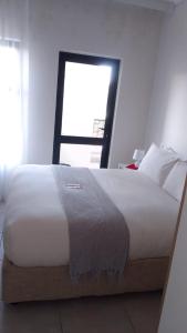 巴利托Ballito Hills Lifestyle Estate Unit 423的卧室配有一张大白色床和窗户