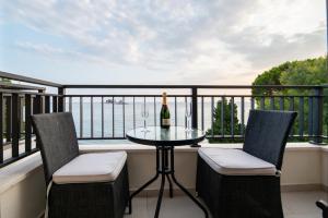 佩特罗瓦纳莫鲁Mar Azul Apartments Petrovac的阳台配有一张桌子和两把椅子,并提供一瓶葡萄酒。