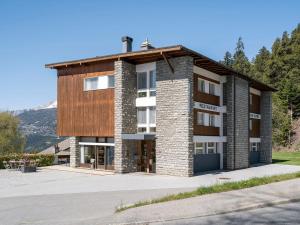 克莱恩 蒙塔纳Hôtel historique Chez Elsy - Crans-Sapins的一座带木屋顶的大型砖砌建筑