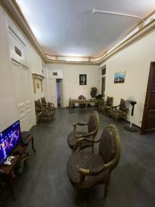开罗cairo central house的客厅配有椅子和平面电视