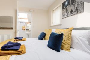 普雷斯顿Oxheys House - 5 Bedrooms Contractors Parking的一张白色的床,上面有蓝色和黄色的枕头