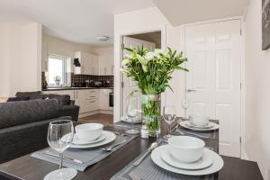 普雷斯顿Oxheys House - 5 Bedrooms Contractors Parking的餐桌,带玻璃杯和花瓶