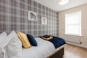 普雷斯顿Oxheys House - 5 Bedrooms Contractors Parking的一间卧室配有蓝色和黄色枕头的床